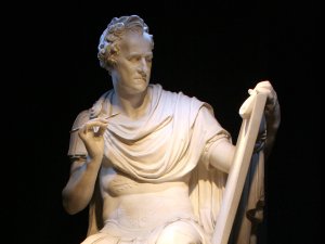 Plaster replica of Antonio Canova’s earlier marble sculpture of George Washington, who is dressed in Roman military armor as Cincinnatus, holding a tablet and quill.