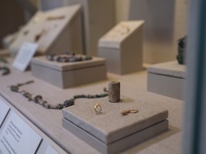 Close-up of a cylinder seal and two golden earrings from ancient Mesopotamia on display at the Kelsey Museum.