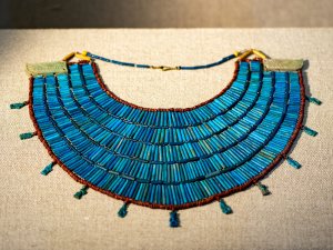Bright-blue Egyptian broad-collar necklace made of strung beads of faience, glass, and ceramic.