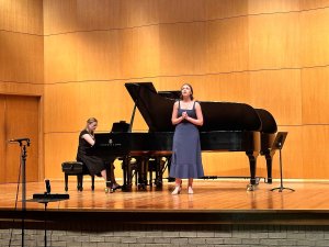 A vocalist and collaborative pianist perform on stage.