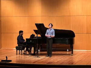 A vocalist and collaborative pianist perform on stage.