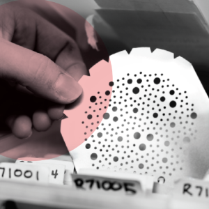 A hand picking up a circular card with dotted patterns from a row of labeled folders.