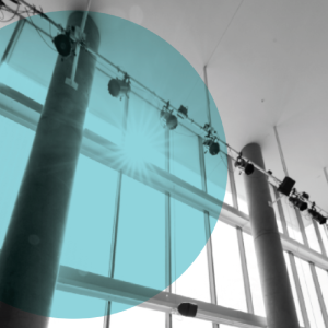 Bright sunlight streams through tall glass windows onto dramatic lighting equipment inside Walgreen Drama Center.