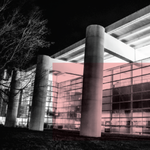 Glass-fronted Power Center building illuminated at night, with modern architecture and strong columns.