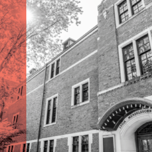 Brick building with several windows and an arched entrance labeled "Lydia Mendelssohn," partially covered by a soft red overlay on the left.