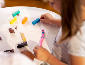 a child making a pink clay snake