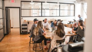 A group of people gather around a table during a meeting