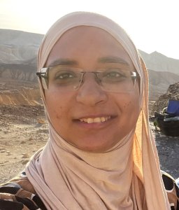 A woman in glasses smiles at the camera