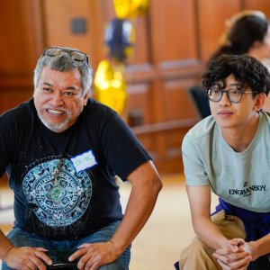 Two people sitting and leaning forward listening