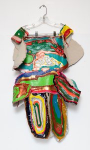 This striking mixed-media sculpture artwork (by artist Jade Saren from Creative Growth) presents a vibrant, wearable or garment-like structure suspended from a clear clothes hanger.