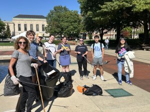 A group of volunteers picking up litter poses for a picture