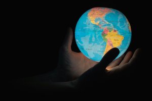 Glowing globe of Earth being embraced in a pair of hands