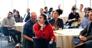 Female student in focus in the midst of a diverse group of people seated