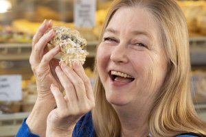 Rebecca Sharpless breaking a large scone in half.