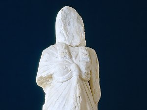 Faceless, armless Graeco-Roman marble statue of Isis wearing a draped gown.