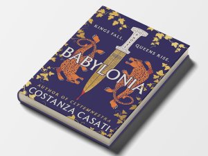 The cover of the novel “Babylonia” by Costanza Casati with an illustration of two leopards surrounding a blade dripping with blood, flanked by the tagline “Kings Fall. Queens Rise.” Gold vines creep around the cover’s perimeter.