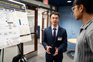 Person in suit presenting research poster