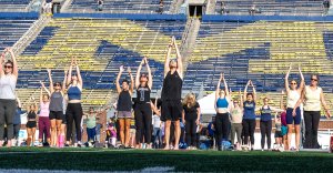 people doing yoga on Michigan Stadium's field