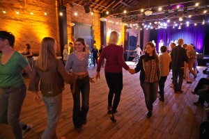 Audience members enjoy square dancing at the Ypsilanti Freighthouse