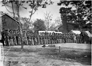 Civil War soldiers stand in front of a cottage