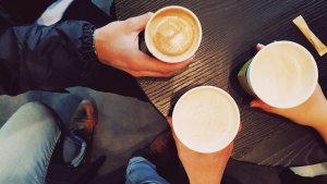 image of multiple coffee cups and people conversing.