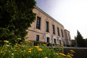 Rackham graduate building facade with yellow flowers in the foreground