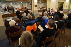A seated audience watches a speaker in Hill Auditorium's Lower Level Lobby.