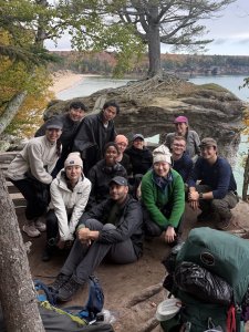 Group of students pose for picture next to wooded and water landscape along Picture Falls National Lakeshore