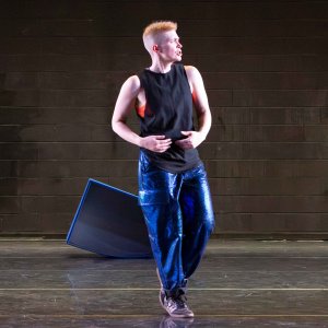Nora Sharp presents standing on a stage in dance rehearsal attire.