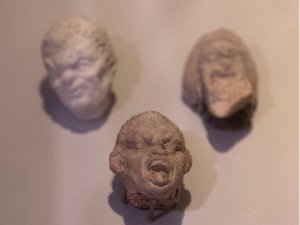 Close-up of three Seleucid grotesques on display at the Kelsey Museum.