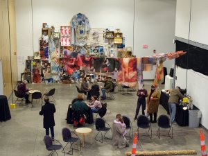 Graduate students, faculty, and visitors gather at the 2025 Open Studios event, amid colorful artwork and installations