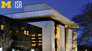 Exterior view of the illuminated ISR Thompson building at night under a deep blue sky, with the University of Michigan Block M and ISR logo in the top left corner.