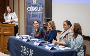 Panel of four female speakers in front of M CLOSUP banner.