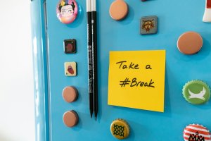 Blue fridge with magnets and a sticky note with the hashtag Take a #Break