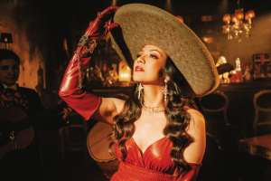 A person in a wide brimmed hat looking up in a corner