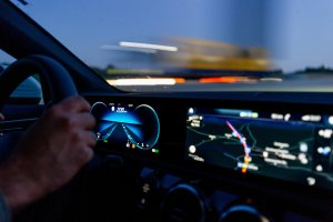 Image of hands on steering wheel with a digital dash