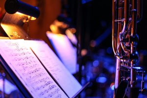 Image of sheet music and a trombone on a stand