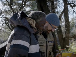 Two men, one Black and one white, walking and talking together