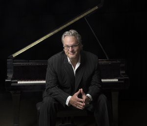 Man sitting in front of a piano