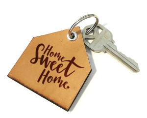 Door key with fob that says home sweet home