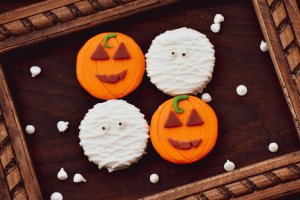 Two mummy themed cookies and two jack-o-lantern themed cookies.