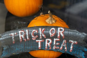 A house window celebrating Halloween with a Trick or Treat sign
