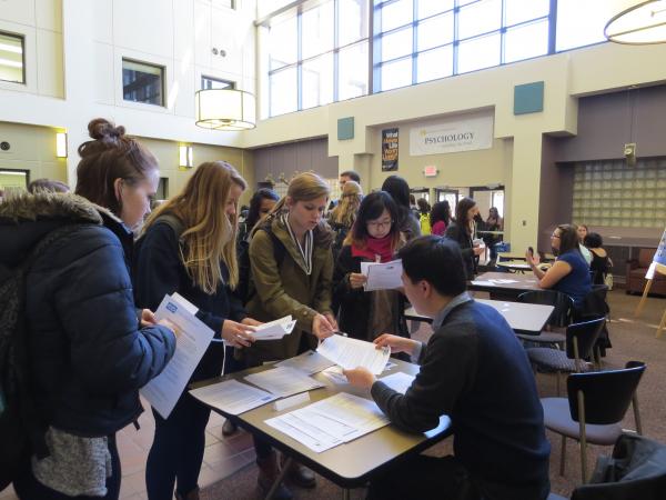 Students talking with researcher at fair