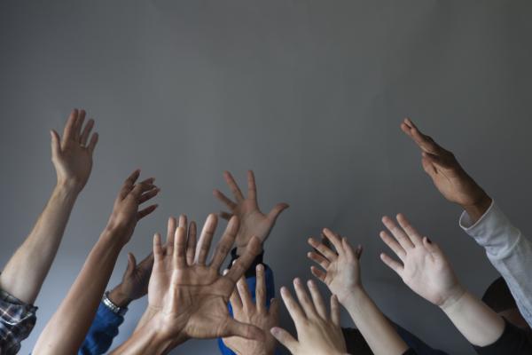 a group of people hold their hands upward