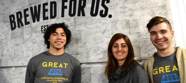 Three U-M students wearing gray T-shirts with the word "GREAT" in yellow block letting.