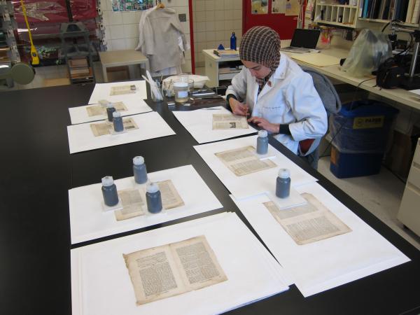 Aisha Wahab, paper conservator, mends pages in the U-M Library Conservation Lab