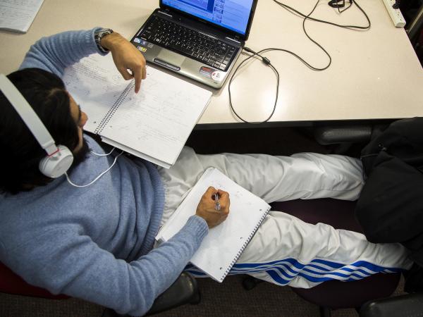 man studying with notebooks and laptop