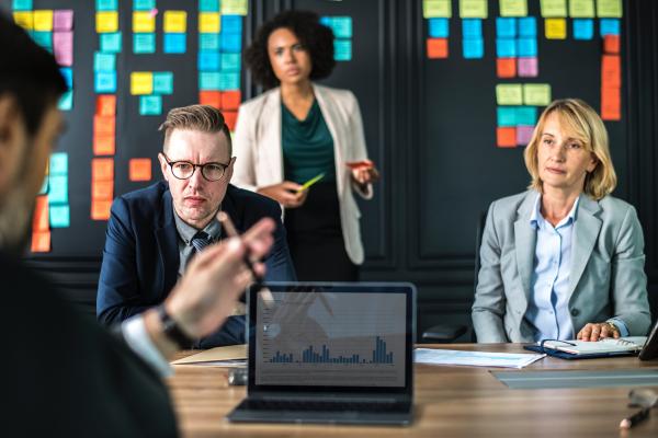 People in a meeting looking at person speaking