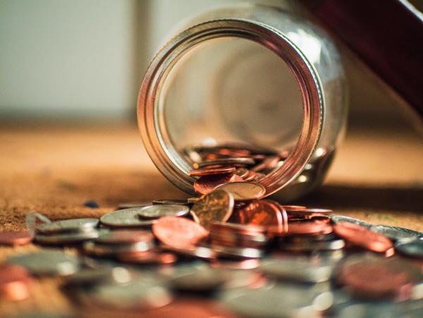 Coin money being spilled out of a jar