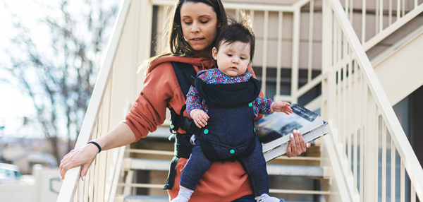 Woman walking down stairs with child and textbooks